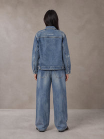 Model wearing the SM Vintage Wash Zip Denim Jacket and SM Heritage Wide Denim Jeans in Marble Blue, rear view.