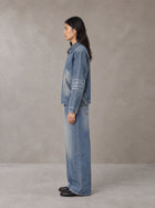 Model wearing the SM Vintage Wash Zip Denim Jacket and SM Heritage Wide Denim Jeans in Marble Blue, side profile.