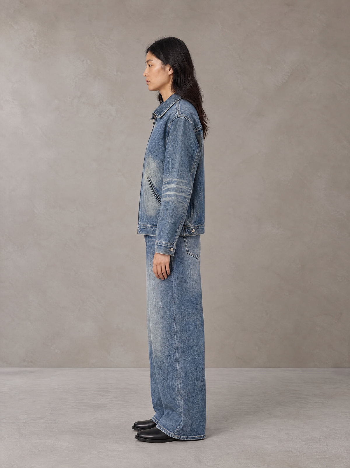Model wearing the SM Vintage Wash Zip Denim Jacket and SM Heritage Wide Denim Jeans in Marble Blue, side profile.