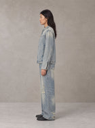 Model wearing the SM Vintage Wash Zip Denim Jacket and SM Heritage Distressed Denim Jeans in Cadet Grey, side profile.