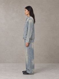 Model wearing the SM Vintage Wash Zip Denim Jacket and SM Heritage Distressed Denim Jeans in Cadet Grey, side profile.