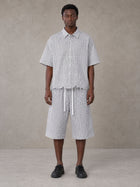 Model wearing the SM Distressed Plaid Boxy Shirt and SM Plaid Capri Shorts in Lucent White, front view.