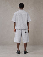 Model wearing the SM Distressed Plaid Boxy Shirt and SM Plaid Capri Shorts in Lucent White, rear view.