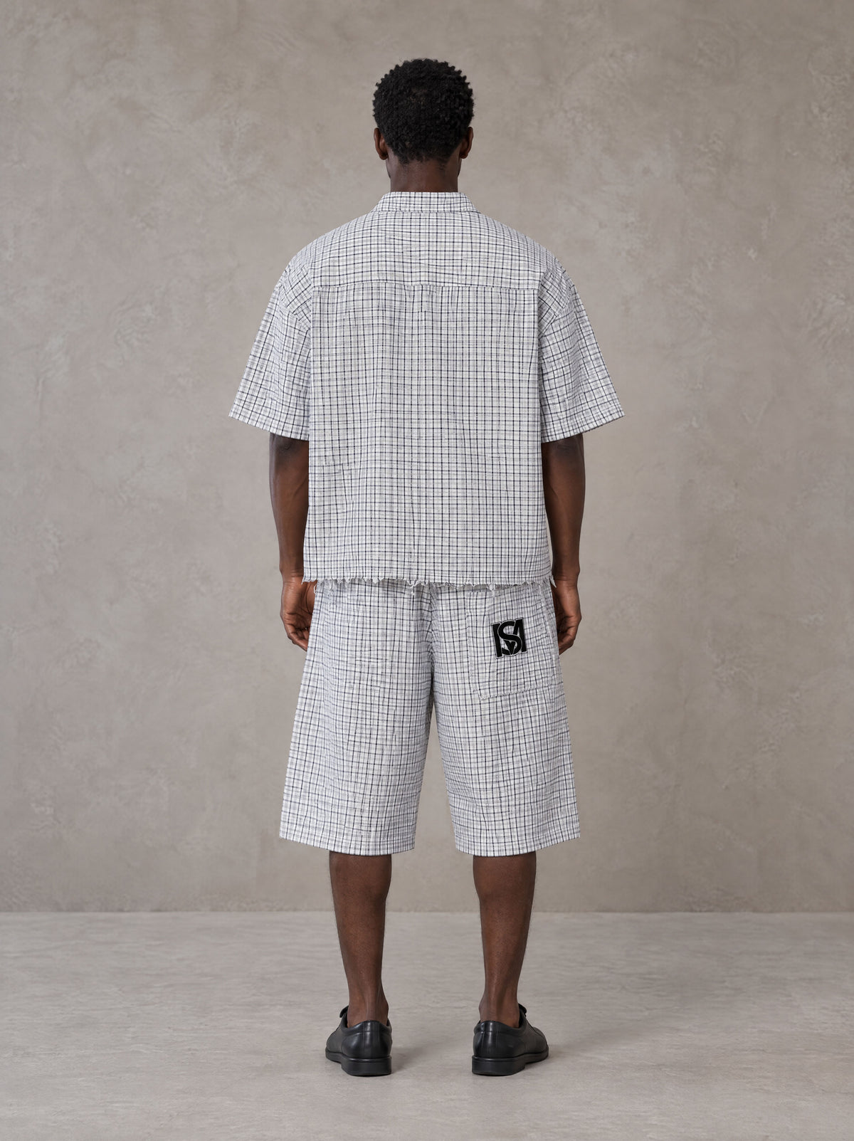 Model wearing the SM Distressed Plaid Boxy Shirt and SM Plaid Capri Shorts in Lucent White, rear view.