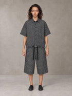 Model wearing the SM Distressed Plaid Boxy Shirt and SM Plaid Capri Shorts in Midnight Black, front view.