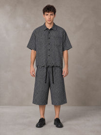 Model wearing the SM Distressed Plaid Boxy Shirt and SM Plaid Capri Shorts in Midnight Black, front view.
