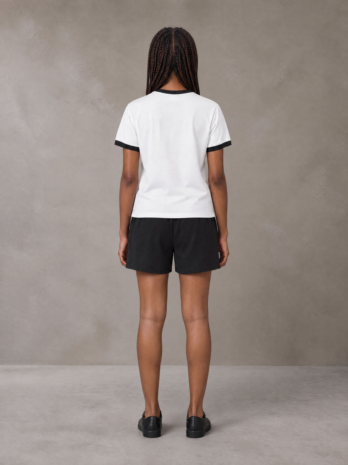 Model wearing the SM London T-shirt in Lucent White with the SM London Shorts in Midnight Black, rear view.