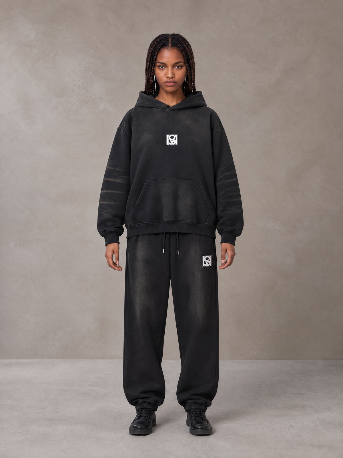 Model wearing the SM Monkey Washed Fleece Hoodie in Midnight Black with the SM Monkey Washed Jogger Sweatpants in Midnight Black, front view.