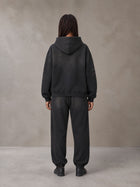 Model wearing the SM Monkey Washed Fleece Hoodie in Midnight Black with the SM Monkey Washed Jogger Sweatpants in Midnight Black, rear view.