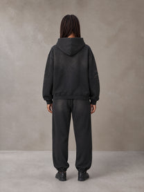 Model wearing the SM Monkey Washed Fleece Hoodie in Midnight Black with the SM Monkey Washed Jogger Sweatpants in Midnight Black, rear view.