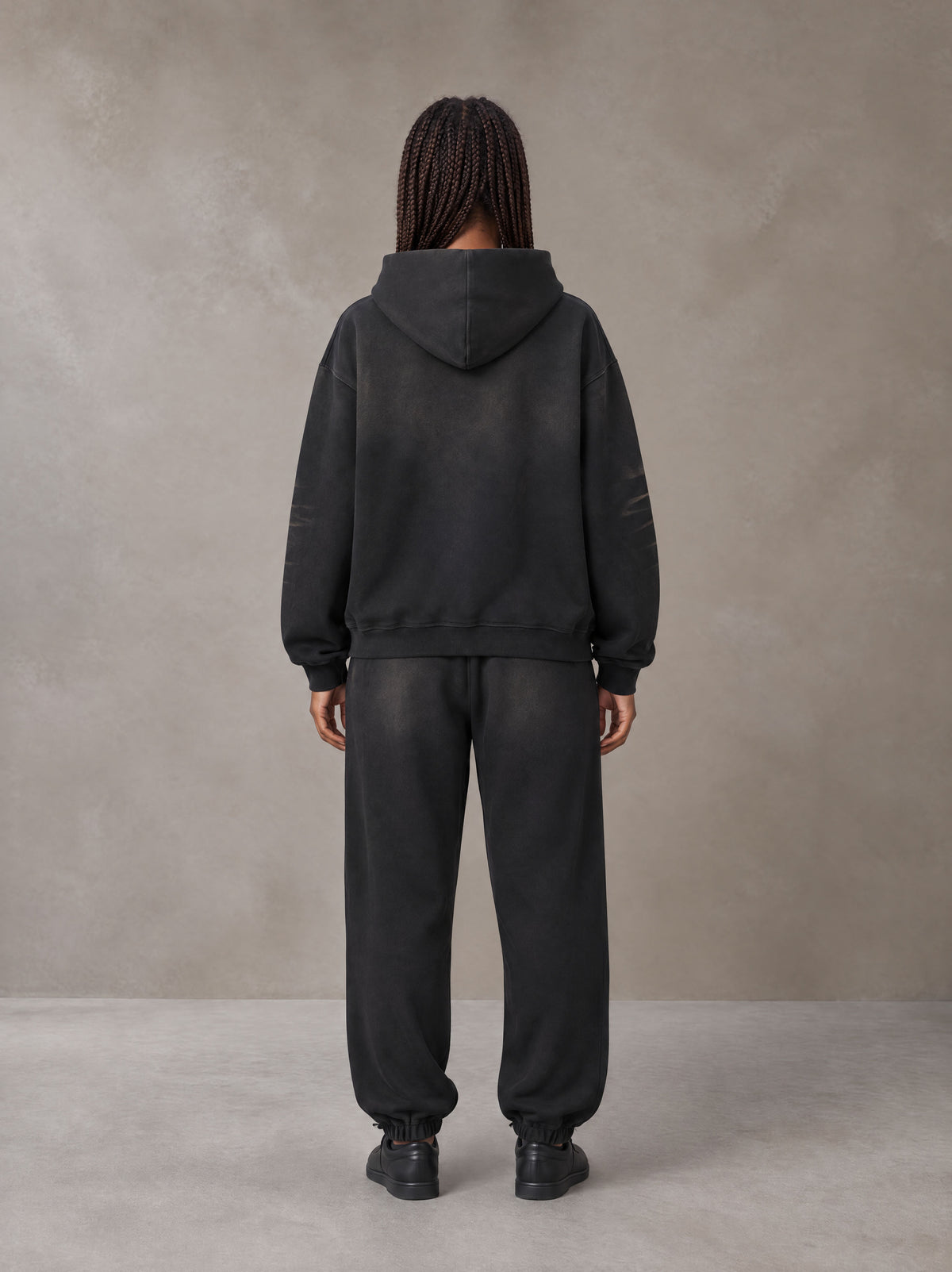 Model wearing the SM Monkey Washed Fleece Hoodie in Midnight Black with the SM Monkey Washed Jogger Sweatpants in Midnight Black, rear view.