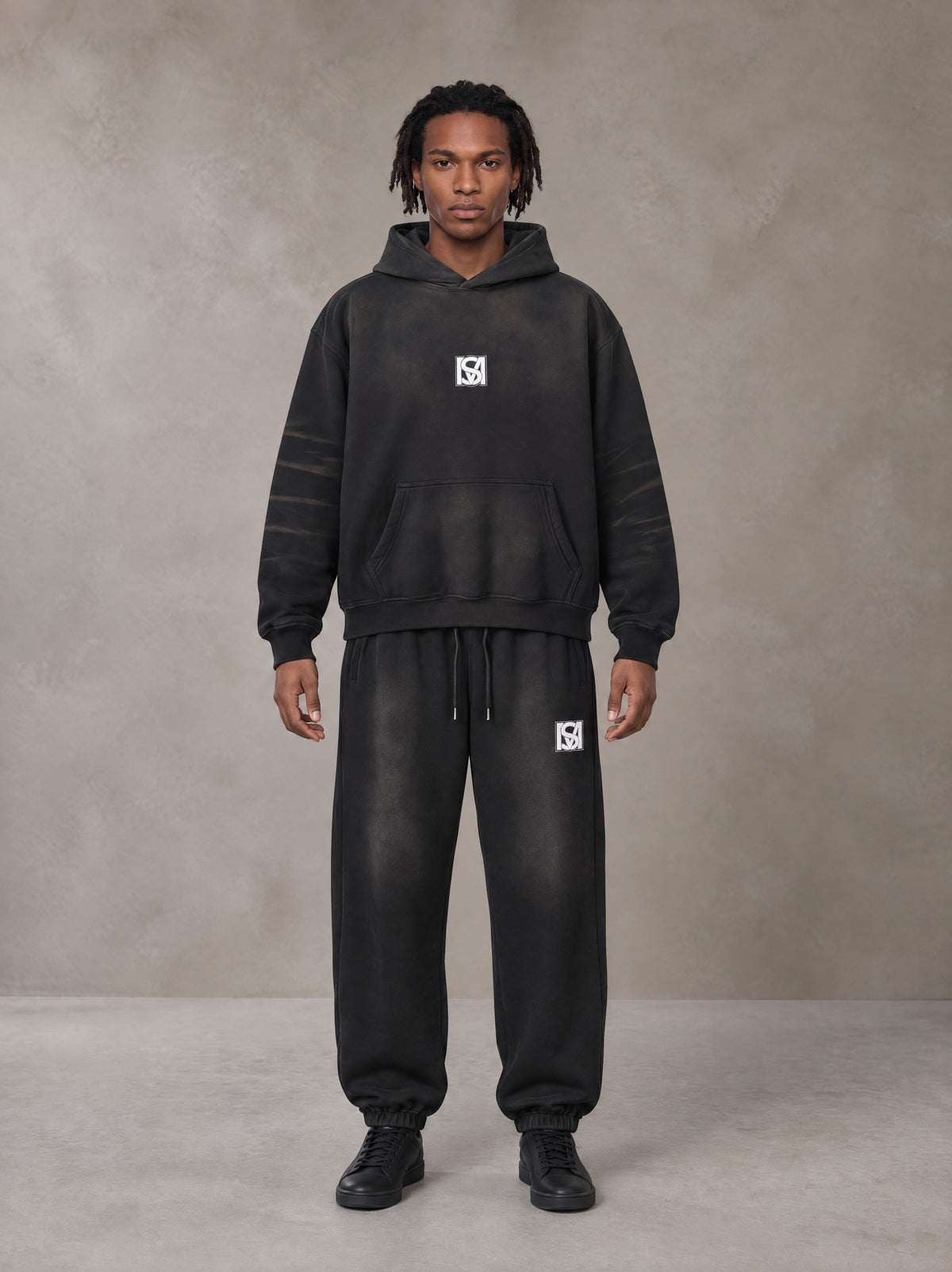 Model wearing the SM Monkey Washed Fleece Hoodie in Midnight Black with the SM Monkey Washed Jogger Sweatpants in Midnight Black, front view.